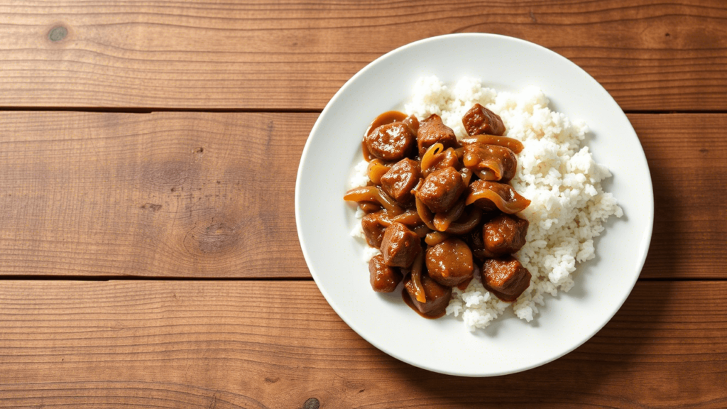 Assiette de boeuf aux oignons, servie avec du riz blanc